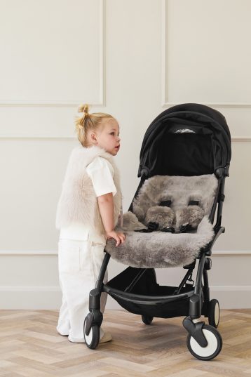 Grey Sheepskin Pram Liner & Strap Cover | Kids | Gushlow & Cole - model next to pram liner side